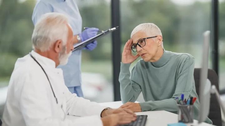 Médica explicando um tratamento para paciente em consultório
